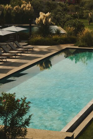 Piscine couverte, piscine extérieure, parasols de plage, chaises longues