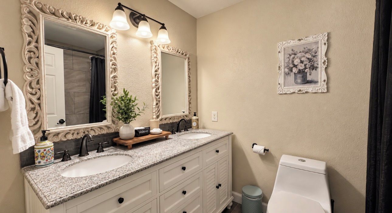 A bathroom with two sinks, a large mirror, and a toilet.