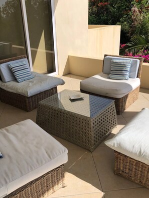 A patio area with wicker furniture, including two sofas and a coffee table.