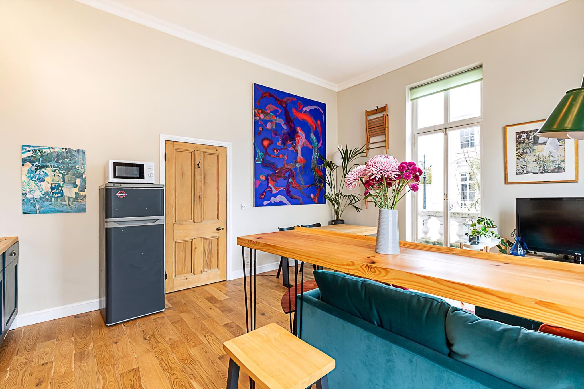 A modern kitchen with a wooden countertop, a built-in microwave, and a refrigerator.