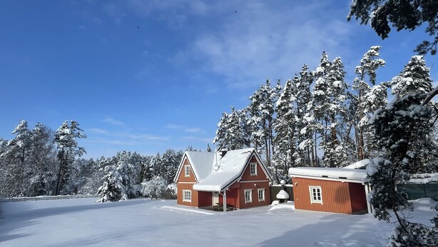 A snow-covered landscape with a red wooden house and a smaller structure, surrounded by snow-laden trees. - Cottage Faflik - Air Con And Own Sauna, Swedish house no 001 (Vlkov)