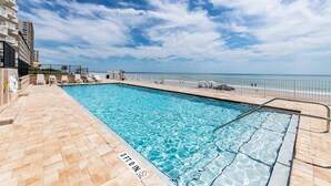 A swimming pool with a 3ft. deep water marker, surrounded by a tiled deck and a beach view. - Chairman of the Board at White Surf (Daytona Beach)