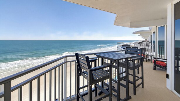 A balcony with a view of the ocean, featuring outdoor seating and a covered area. - Chairman of the Board at White Surf (Daytona Beach)