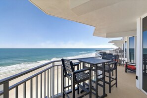 A balcony with a view of the ocean, featuring outdoor seating and a covered area. - Chairman of the Board at White Surf (Daytona Beach)