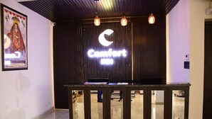 Una recepción con un letrero de neón que dice "Comfort Inn" y un cuadro en la pared.