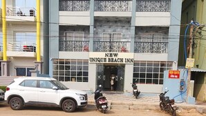 A building with a sign reading "NEW UNIQUE BEACH INN" and "A UNIT OF SHAMUKA HOTELS". - Shamuka Hotel (Puri)
