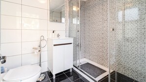 A modern bathroom with a toilet, sink, and shower area. - Teixeira 's House (Tavira)