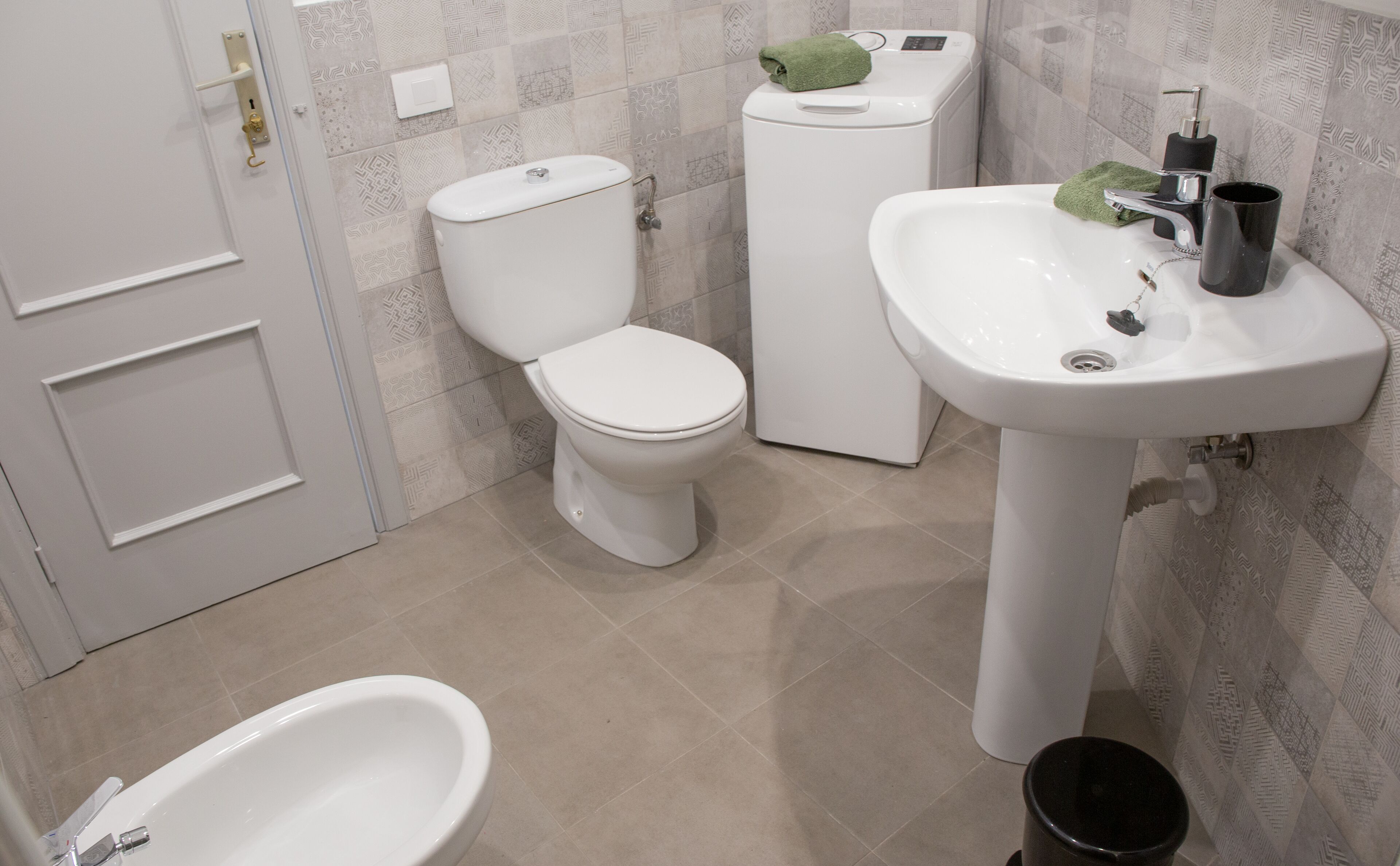 A bathroom with a toilet, sink, and bidet.