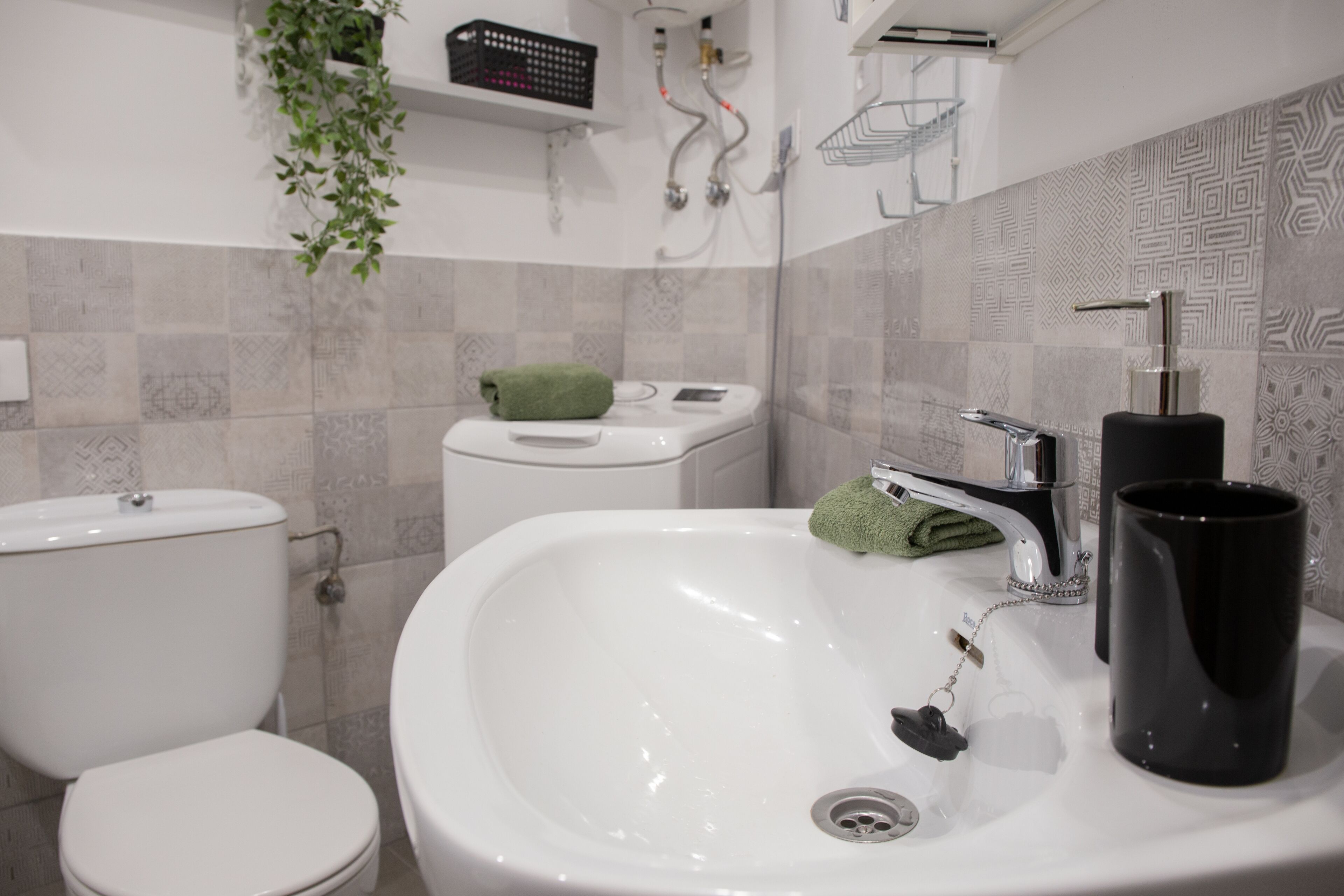 Ein Badezimmer mit weißem Waschbecken, Toilette und Duschbereich.