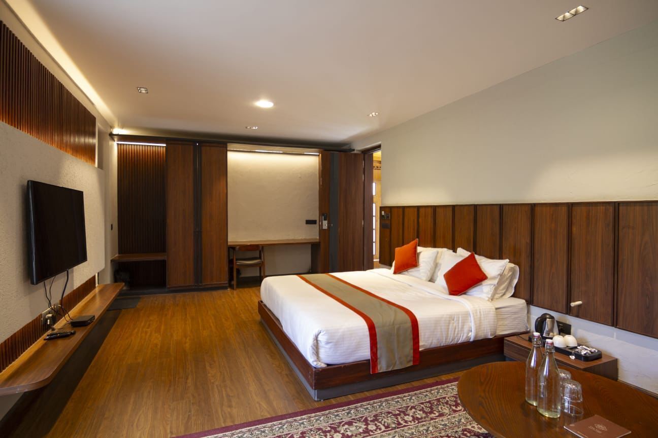 Une chambre d’hôtel équipée d’un lit, d’une télévision, d’un bureau et d’une table de chevet.