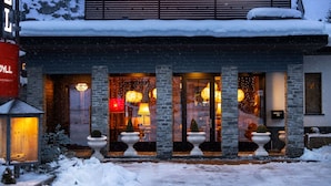 Un hotel con fachada de piedra, ventanas amplias e iluminación exterior.