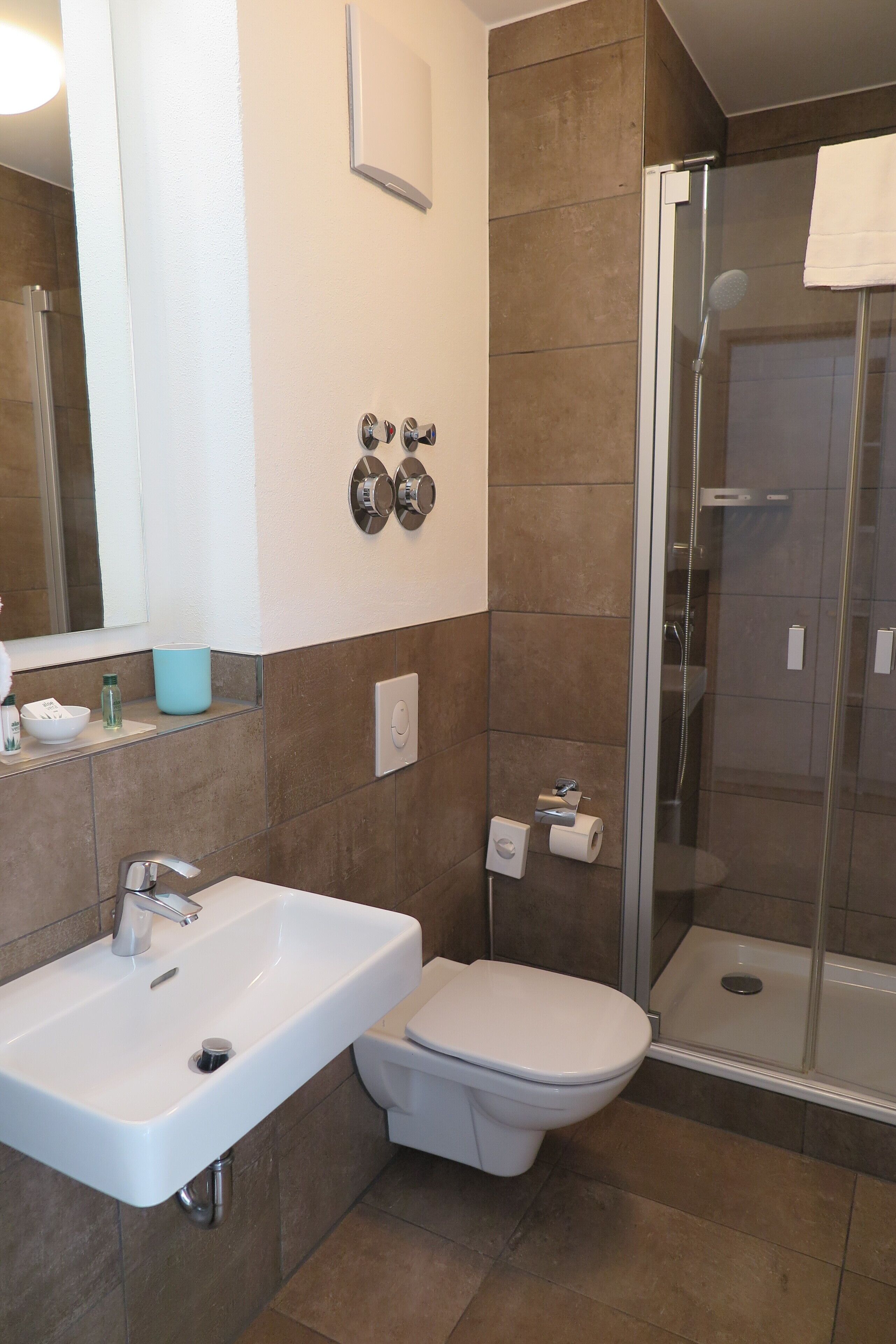 Ein modernes Badezimmer mit Waschbecken, Toilette und einer Duschkabine.