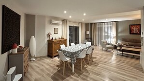 Un vaste espace de vie comprenant une table à manger entourée de chaises, un canapé et un meuble en bois.