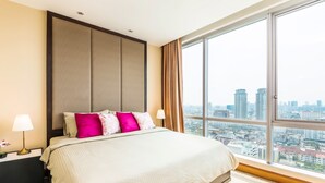A hotel room with a large bed, a nightstand, a lamp, and a view of the city through a large window. - Serviced 2 Bed Scenic Sky Villas - Check in From 15h to 22h Only (Bangkok)
