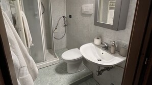 A modern bathroom with a glass shower enclosure, a toilet, a sink with a mirror, and a towel rack. - Rome 23, apartment in Rozzano (Rozzano)
