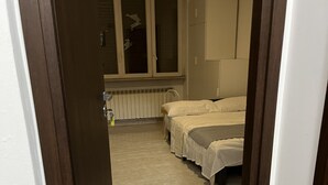 A hotel room with a bed, a window, and a radiator. - Rome 23, apartment in Rozzano (Rozzano)