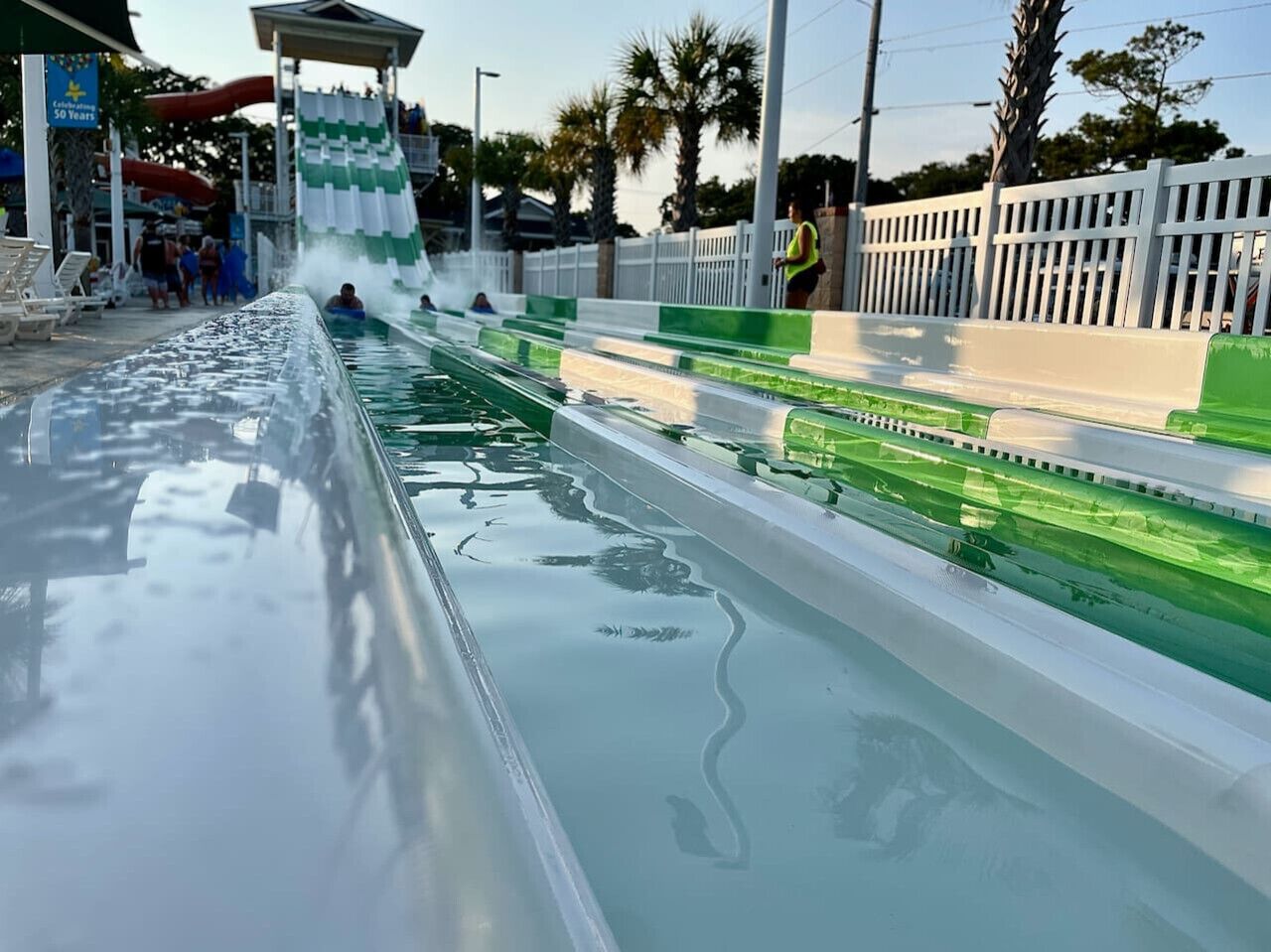 A water slide at a water park with a person sliding down.