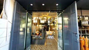 A hotel entrance with a sign reading "HOTEL NEAR ME" and a location pin icon. - Hotel Near Me (Rajkot)