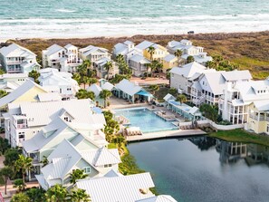 Guests can enjoy ocean views from the resort's gabled-roof buildings, which surround a central pool and lounge areas.