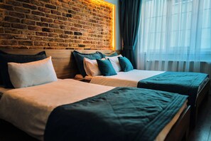 Habitación triple familiar, varias camas | Minibar, caja de seguridad en la habitación, escritorio y wifi gratis