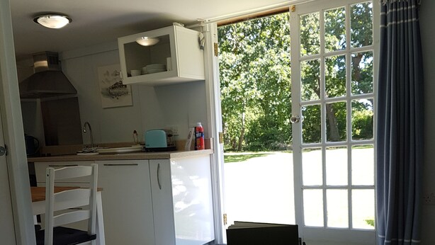 A compact living space with a kitchen, dining area, and a large window.