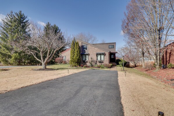 A two-story house with a driveway leading to the front door.