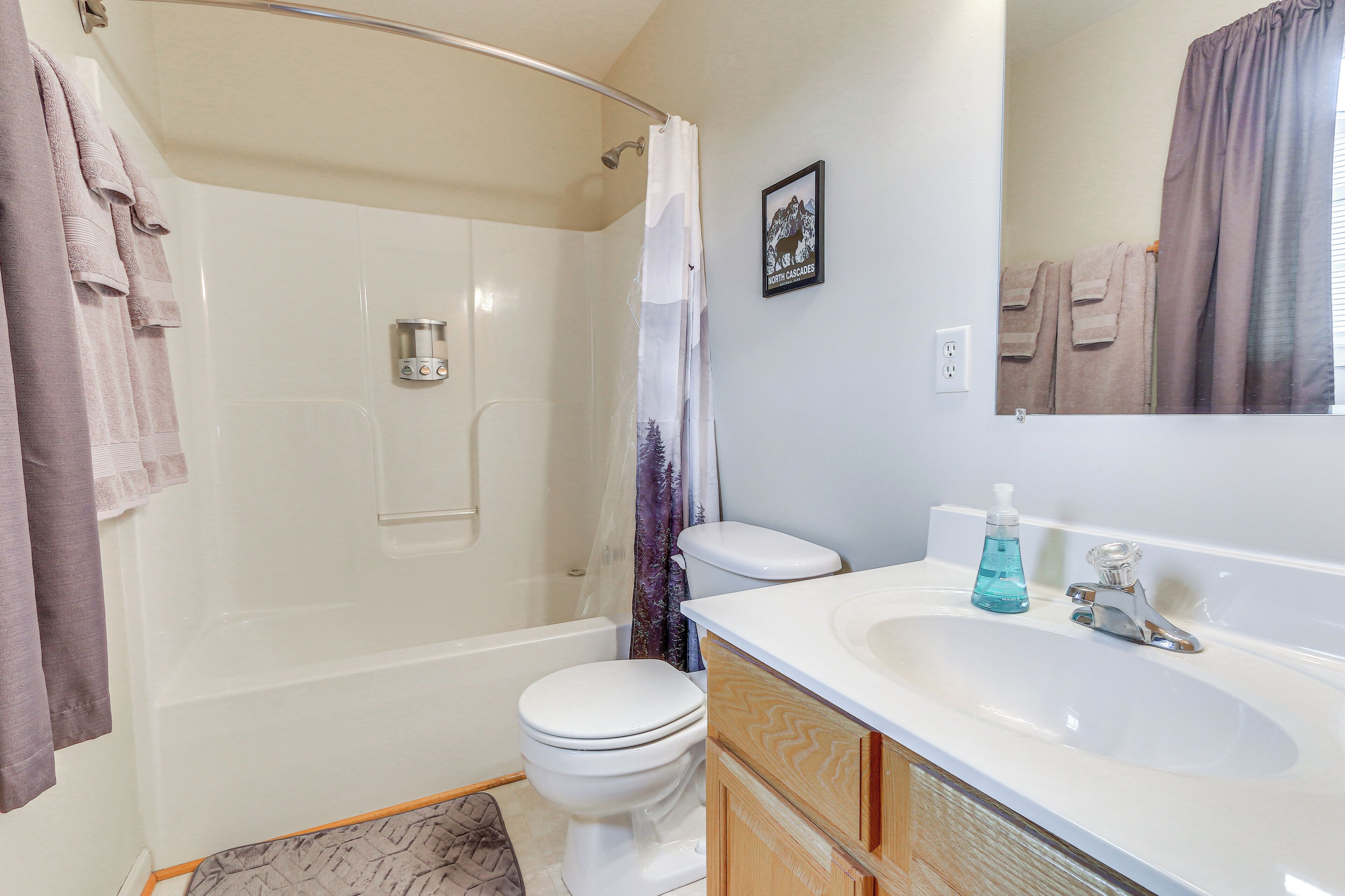 A bathroom with a bathtub, toilet, and sink.