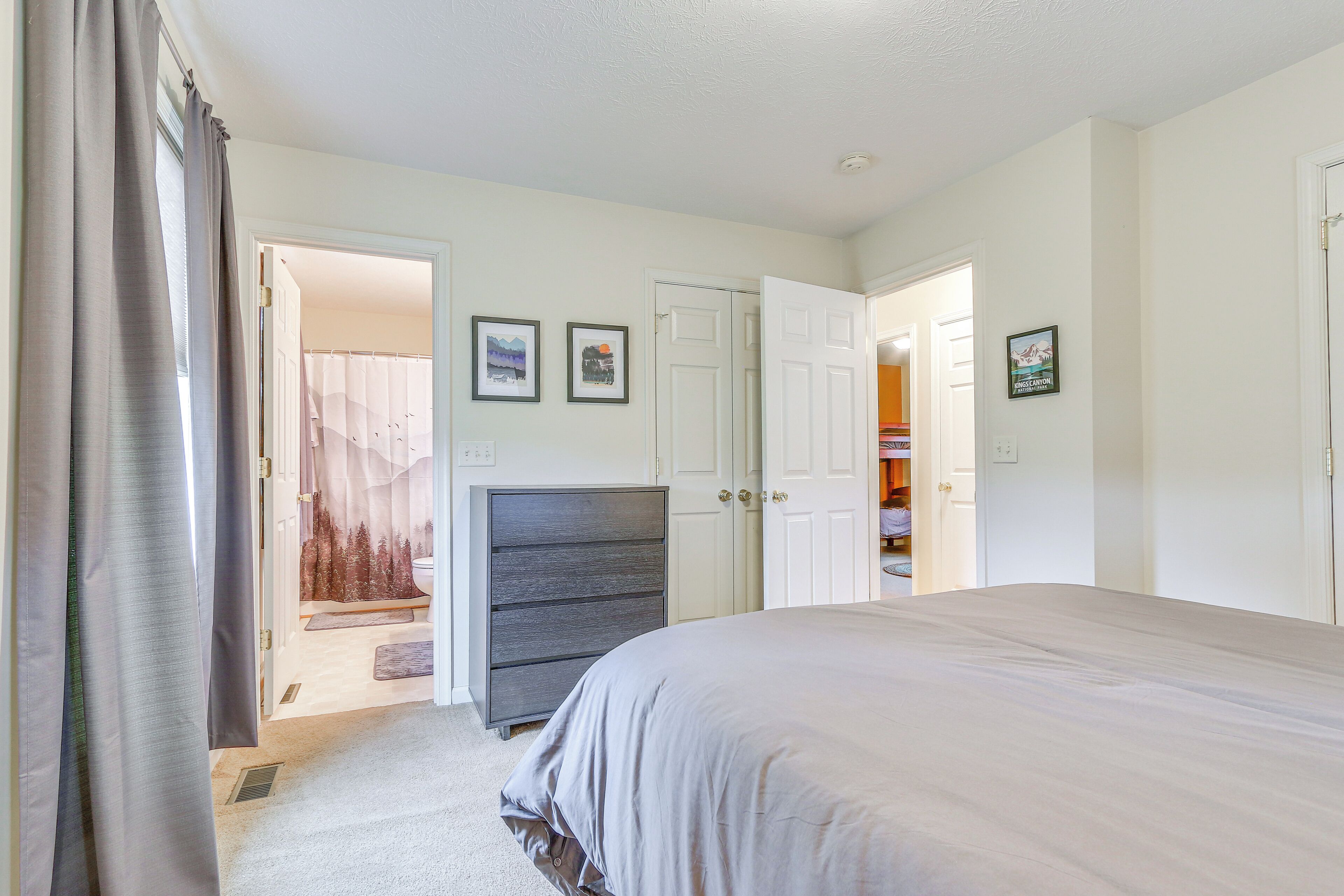 Une chambre à coucher avec un grand lit, une commode et un placard.