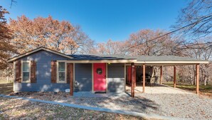 A single-story house with a red door, a covered porch, and a gravel driveway. - ~ 3 Mi to Lake Texoma: Kingston Family Retreat (Kingston)