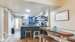 A kitchen with a central island, wooden stools, and a framed quote on the wall. - ~ 3 Mi to Lake Texoma: Kingston Family Retreat (Kingston)