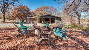 A cabin with a porch, outdoor seating, and a view of trees and a clear sky. - ~ 3 Mi to Lake Texoma: Kingston Family Retreat (Kingston)