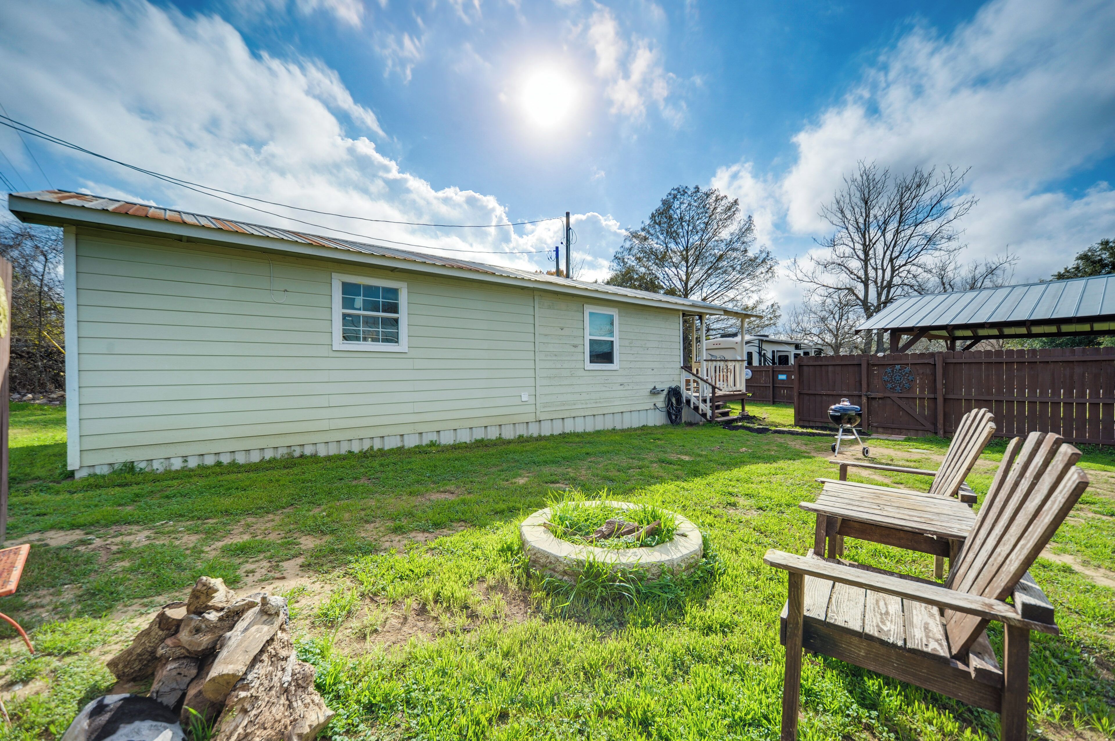 A single-story house with a small front yard, a wooden deck, and a barbecue grill.