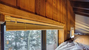 A wooden interior with a bed, a window with a view of trees, and a wooden ceiling. - Mountain-view Condo in Brian Head w/ Private Sauna (Brian Head)