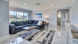 A modern living room with a sectional sofa, a coffee table, and a rug. - Game Room + Screened Lanai: Pine Island Getaway! (Saint James City)