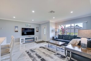 Un salon moderne avec un téléviseur à écran plat, une cheminée, un canapé et une table basse.