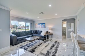 Un salon moderne avec un canapé d’angle, une table basse et un tapis.