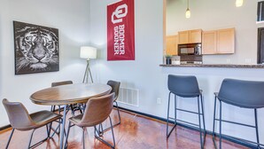 Une cuisine moderne avec des meubles en bois, un four à micro-ondes et un coin bar équipé de tabourets.