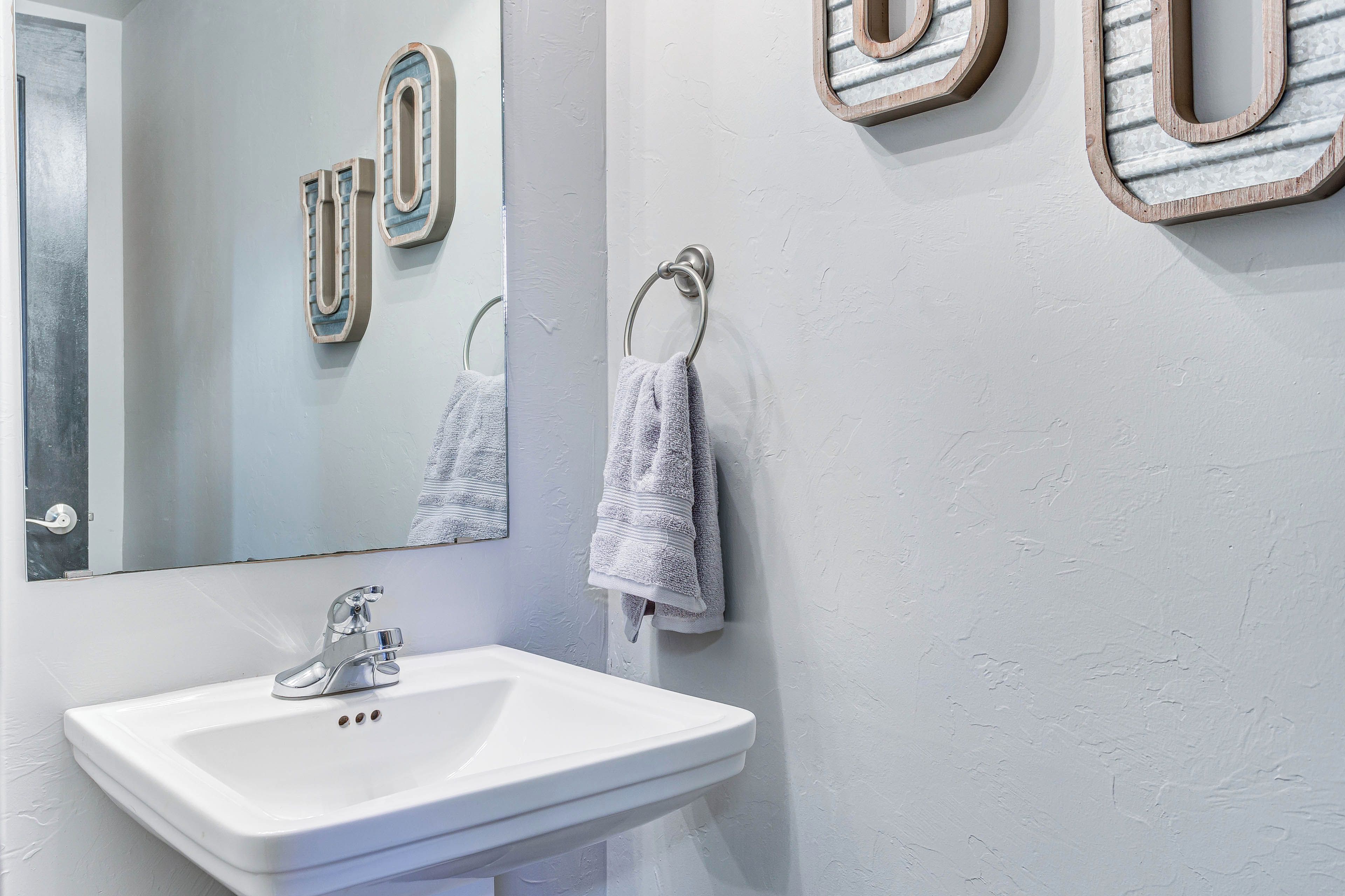 A bathroom with a white sink, a mirror, and a towel ring.