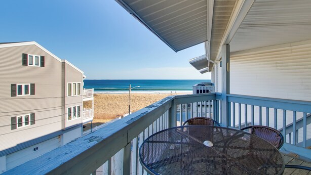 Un balcon avec vue sur la plage et l’océan.