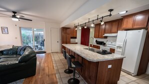 Une cuisine moderne avec des meubles en bois, un plan de travail en granit et un four encastré.