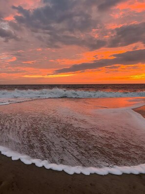 Una playa con olas y un cielo al atardecer.