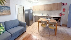 A compact kitchen with a refrigerator, microwave, and wooden cabinets. - Forster Lodge 6: 1  BR, 1  BA Apartment in Forster, Sleeps 4 (Forster)