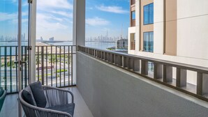 A balcony with a view of a city skyline, including a prominent skyscraper. - HomesGetaway-Lavish2BR in CreekBayshore4 (Dubai)