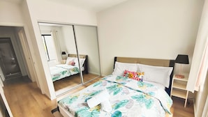 Ein Schlafzimmer mit Bett, Nachttisch, Lampe und Spiegel.
