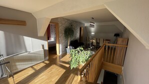 Ein großzügiges Loft mit hohen Decken, Holzboden, Essbereich und einer Treppe.