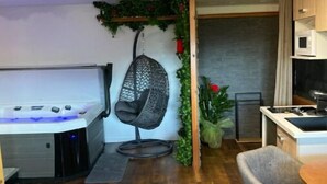 Ein modernes Wohnzimmer mit Whirlpool, einer Hängemattenliege und einem Essbereich.