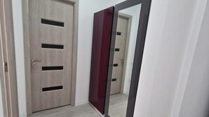 A room with a wooden door with two black handles and a mirror on the wall. - BBC Apartments (Navodari)