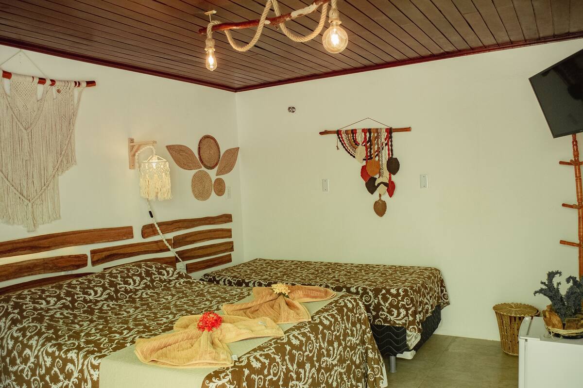 A room with a bed, wooden headboard, wall decorations, and a television.