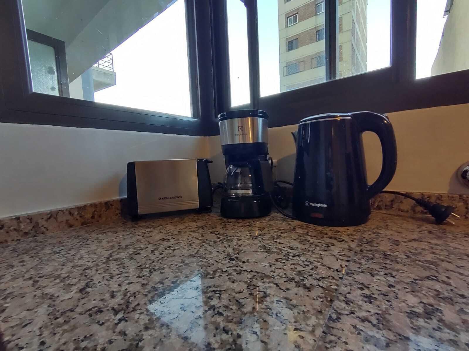 A kitchen counter with a Ken Brown coffee maker, a Westinghouse electric kettle, and a coffee pot.