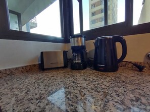 A kitchen counter with a Ken Brown coffee maker, a Westinghouse electric kettle, and a coffee pot.